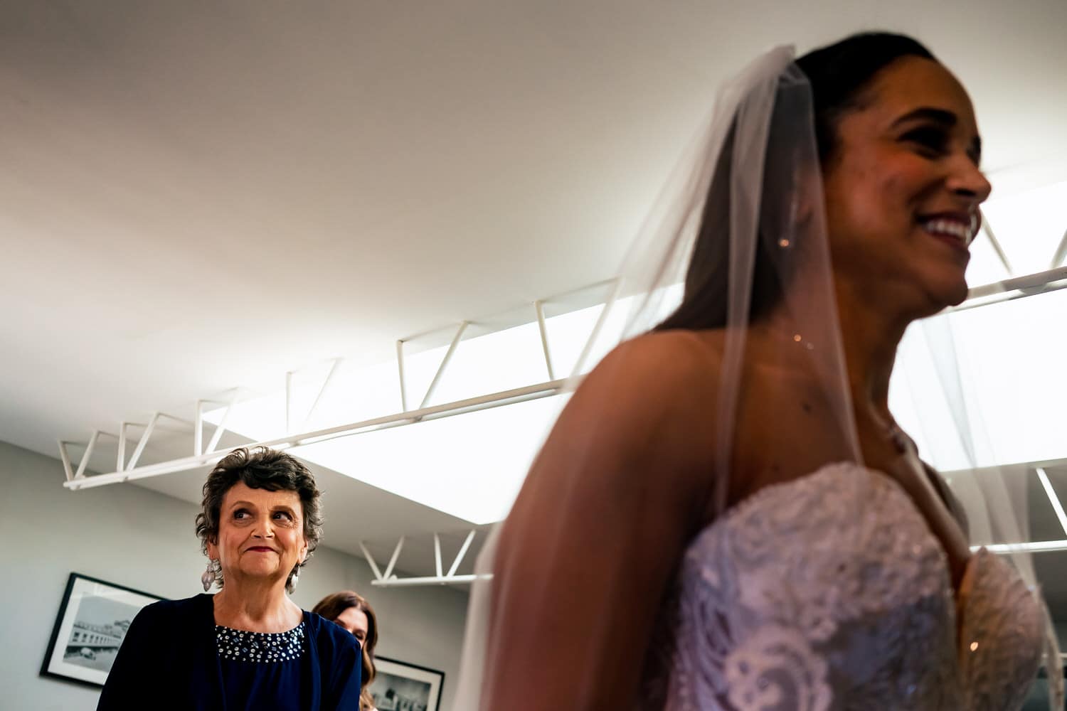 A candid picture of a bride looking at her reflection in the mirror at 28 Event Space on her summer wedding day. 