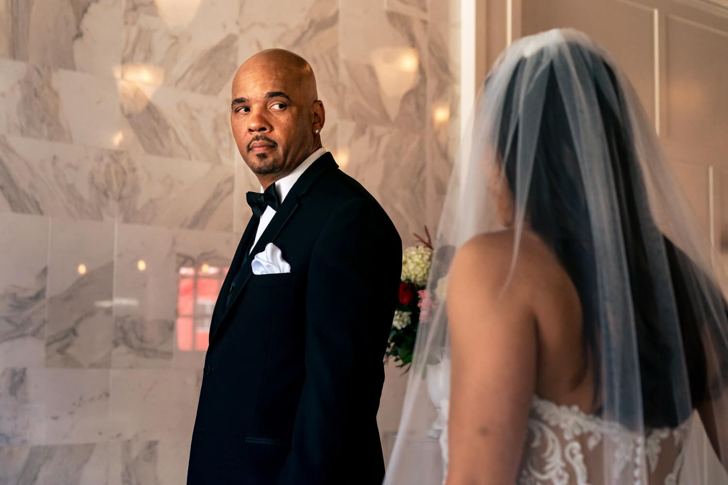 A colorful, candid picture of a groom turning around to see his bride for the first time on their summer wedding day at The Station in Kansas City. 
