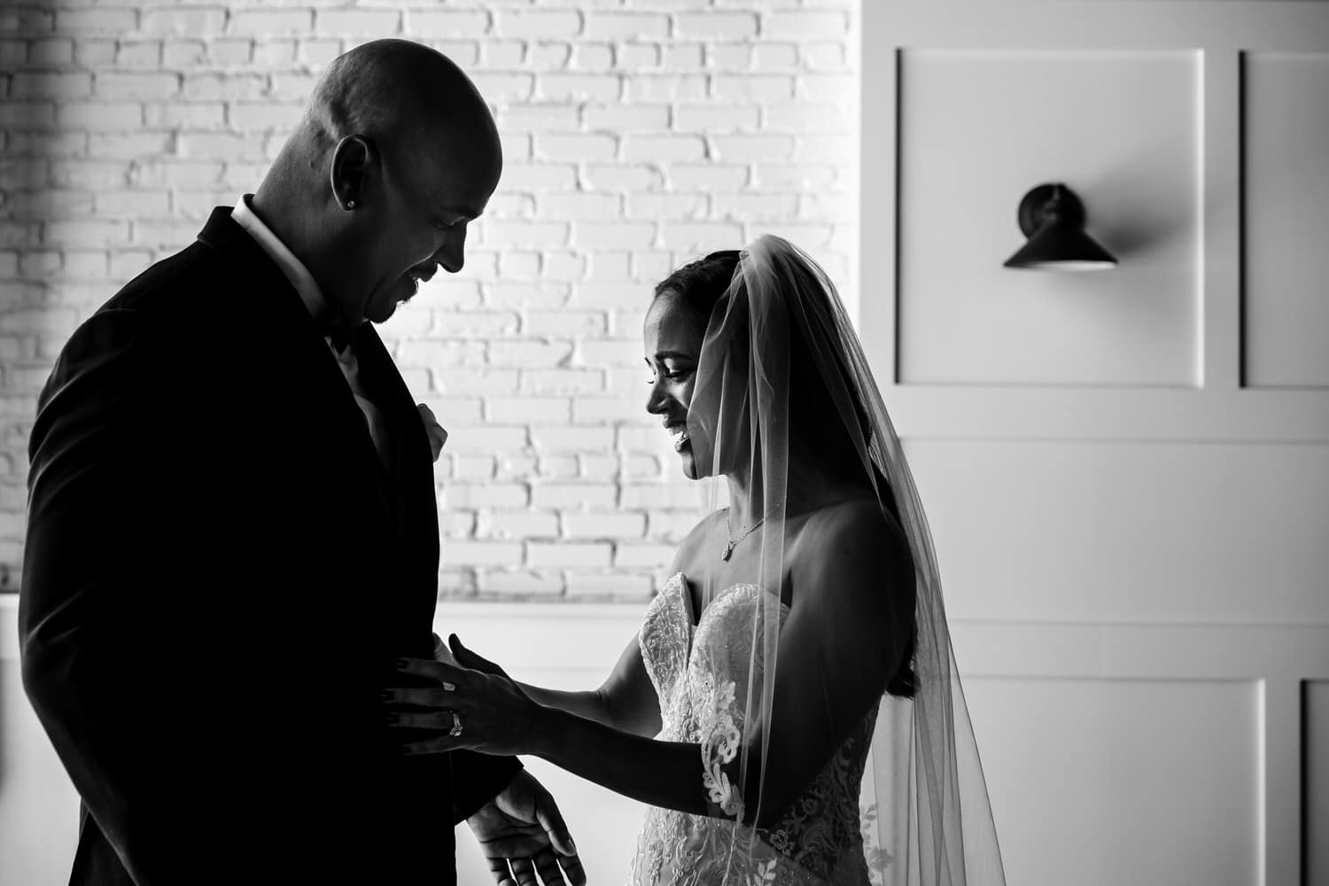 A candid black and white picture of a groom in a black and white tuxedo lovingly looking at his bride on their summer wedding day in Kansas City. 