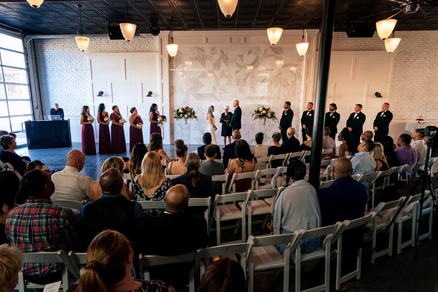 A wide photograph of a wedding ceremony at The Station at 28 Event Space in Kansas City. 