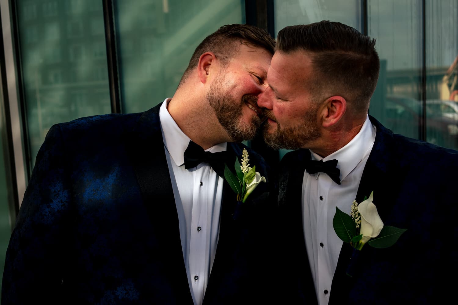 A close-up portrait of a groom leaning in to kiss his groom on their fall wedding day in Kansas City. 