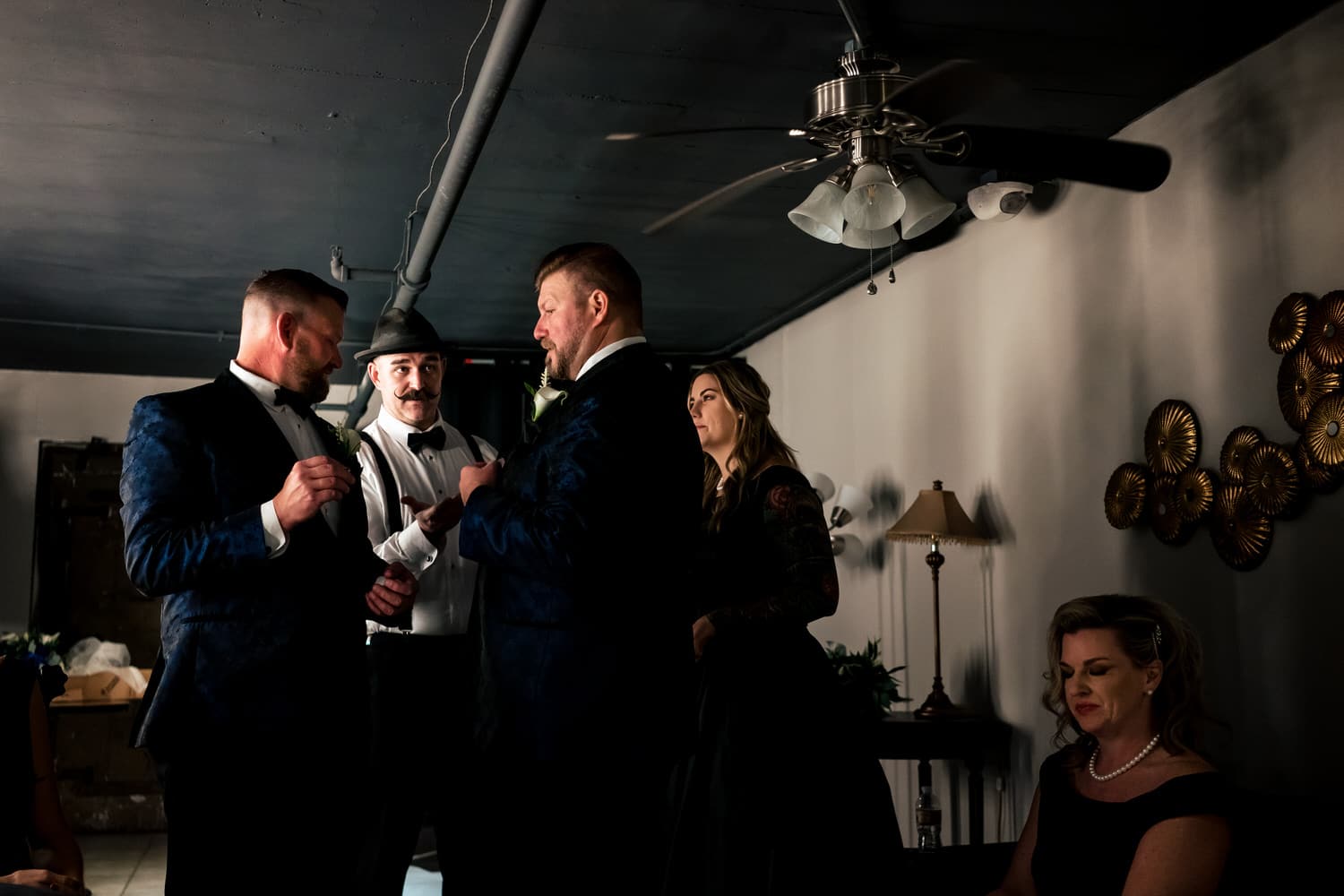 A candid picture of two grooms and their wedding party getting ready for a wedding ceremony at The Madrid Theatre in Kansas City. 