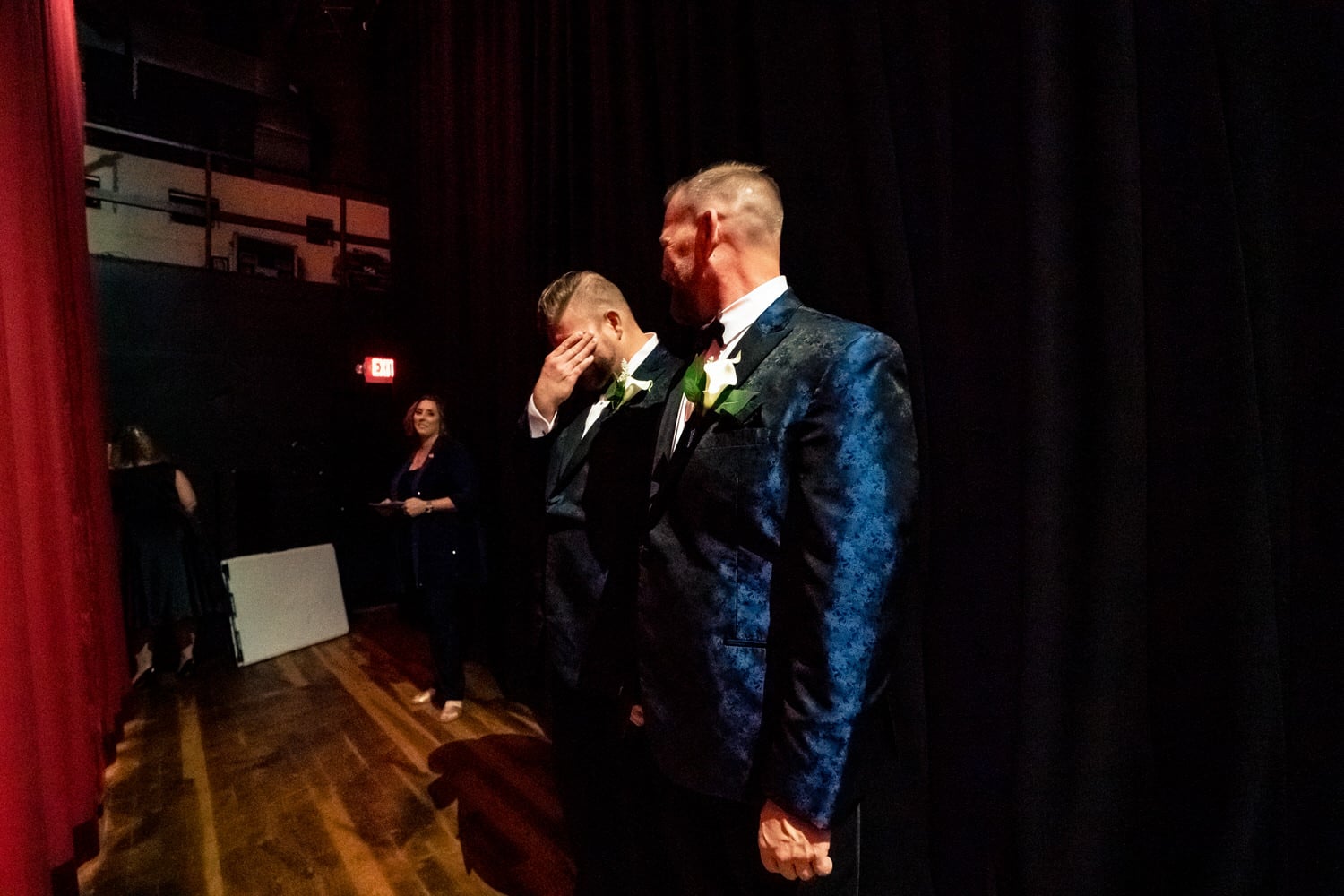 A candid picture of a groom wiping tears from his eye moments before his wedding ceremony starts at The Madrid Theatre in Kansas City. 