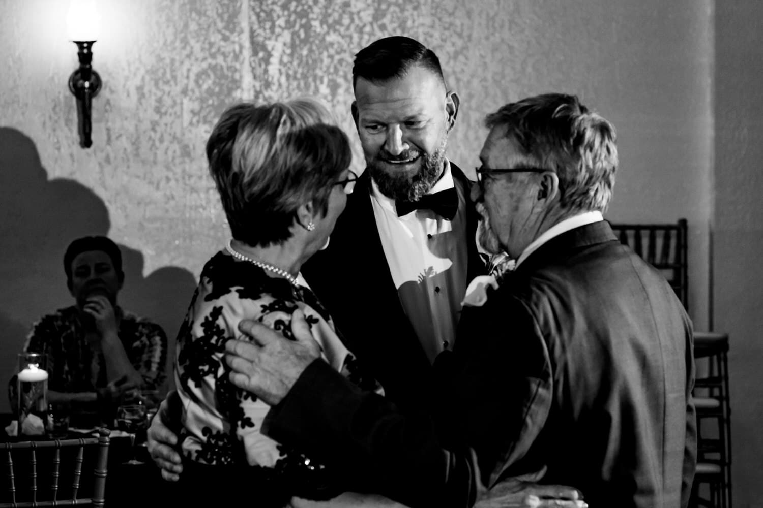 A candid picture of a groom dancing with his mom and dad during his fall wedding reception at The Madrid Theatre in Kansas City. 