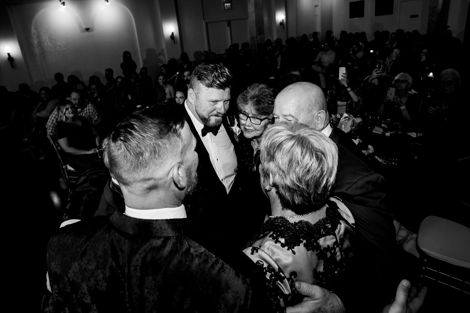 A candid picture of a groom dancing with his mom and dad during his fall wedding reception at The Madrid Theatre in Kansas City. 