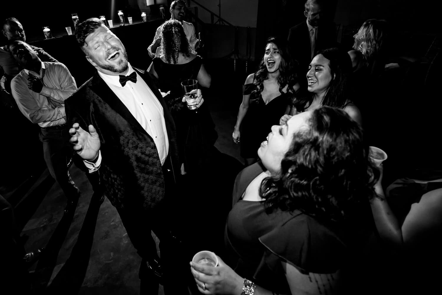 A candid picture of wedding guests dancing on the dance floor during a fall wedding reception at The Madrid Theatre in Kansas City. 